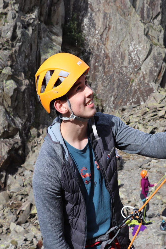 A man in a helmet grinning and looking up